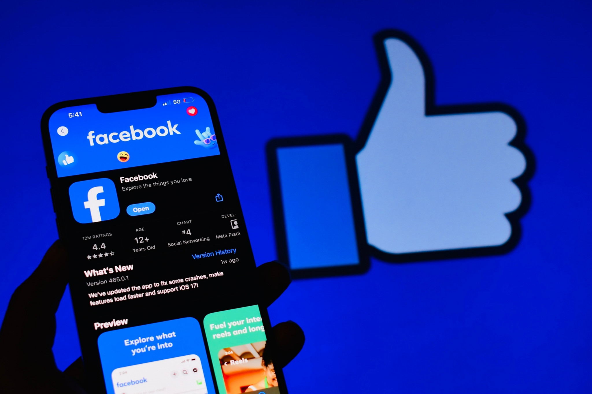 Ao fundo, ícone de curtir do Facebook; à frente, página do facebook na loja de aplicativos de celular